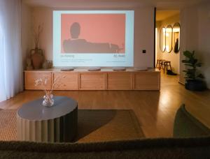 a living room with a large screen with a table at B5 Apartment in Făgăraş