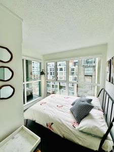 a bedroom with a bed and a large window at Luxury condo beach side Yaletown in Vancouver +18 photos