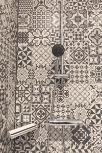 a bathroom with a tile wall with two stools at Fewo Adam und Eva in Bamberg