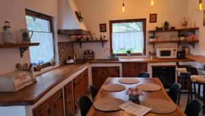 a kitchen with wooden counters and tables and windows at Rustic Dreams-Dobolii de Sus in Dobolii de Sus