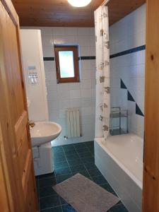 um banheiro com banheira, pia e banheira em Permadieshof L em Sankt Leonhard im Pitztal