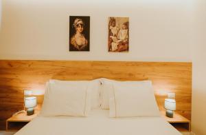 a bedroom with a bed with two pictures on the wall at Hotel Delicia in Shkodër