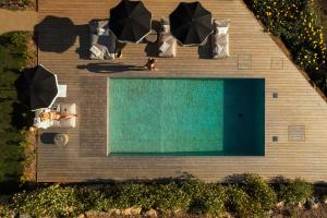 an overhead view of a swimming pool with umbrellas at oceanHUTS Coxos Adults Only from age 14 in Ericeira