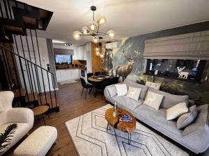 a living room with a couch and a dining room at Dotyk Tatr in Rzepiska