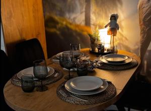 a wooden table with plates and wine glasses on it at Dotyk Tatr in Rzepiska