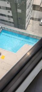 a swimming pool on top of a building at Flat no Beach Class Internacional, à beira-mar, em Boa Viagem, Recife-PE, com portaria e restaurante 24h - ideal para concursos, turismo, visto americano e jogos da série A - Piscina em reforma in Recife