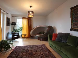 ein Wohnzimmer mit einem Sofa und einem Stuhl in der Unterkunft Appartement Györi. in Millstatt