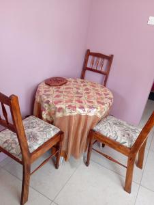 a table and two chairs with a table and a table at Daniel's comfort in Canefield