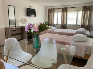 a living room with a glass table and white chairs at Hotel y Restaurant ISIDORA in Arica