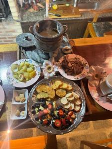 a table topped with plates of food on a table at Minas Em Marambaia in Rio de Janeiro