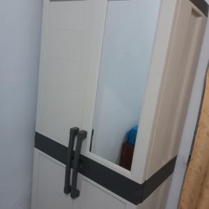 a white cabinet with black handles in a room at Graha Azzam House in Sidoarjo