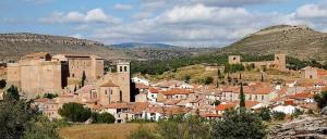a group of buildings in a town with mountains at Casa Las Torres in Mora de Rubielos