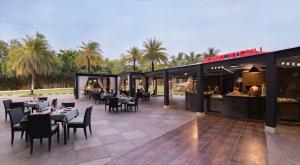 a restaurant with tables and chairs on a patio at Novotel Hyderabad Convention Centre in Hyderabad