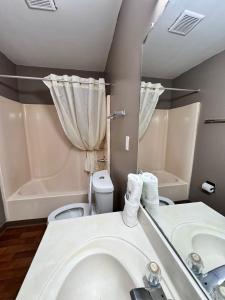 a bathroom with a sink and a toilet and a tub at Live In Lodge Marietta in Marietta