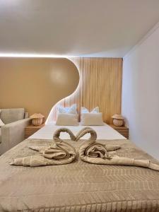 una camera da letto con un letto con un paio di asciugamani di serpente di Kay Pampa a Sainte-Luce