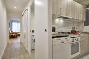 a kitchen with white cabinets and a stove top oven at BBarcelona Gracia Apartment in Barcelona