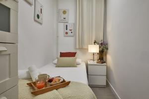 a bedroom with a bed with a tray of food on it at BBarcelona Gracia Apartment in Barcelona