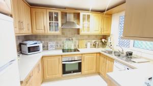 a kitchen with wooden cabinets and a sink at Le joyau Andalou in Estepona