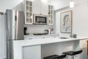 コリングウッドにある1 bedroom Garden Suite with parking, Best Locationの白いキャビネットとステンレス製の冷蔵庫を備えたキッチン +5枚の写真