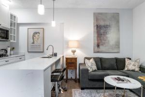 コリングウッドにある1 bedroom Garden Suite with parking, Best Locationのソファとテーブルのあるキッチンとリビングルーム