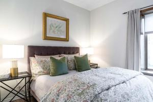 コリングウッドにある1 bedroom Garden Suite with parking, Best Locationの緑の枕が付いた大きなベッドのある寝室