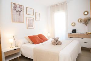 biała sypialnia z łóżkiem i ręcznikami w obiekcie Summer Beach House w mieście Puebla de Farnals