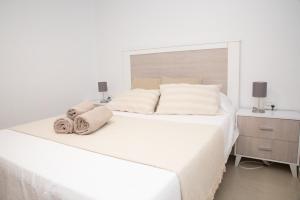 białe łóżko z ręcznikami w sypialni w obiekcie Summer Beach House w mieście Puebla de Farnals +29 zdjęć