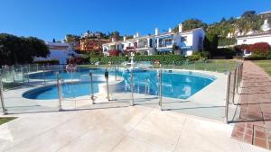 a swimming pool with a fence around it at Le joyau Andalou in Estepona