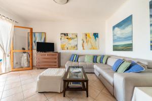 un salon avec un canapé et une table dans l'établissement Villino Iris 8 Is Molas Golf Resort, à Is Molas 