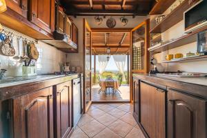 une cuisine avec des placards en bois et une table en arrière-plan dans l'établissement Villino Iris 8 Is Molas Golf Resort, à Is Molas 