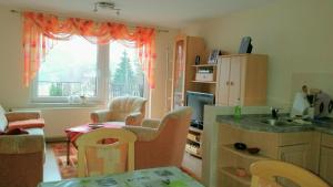 a kitchen with a table and chairs and a window at Ferienhaus Riedl in Klingenthal