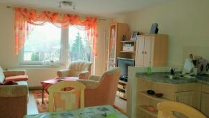 eine Küche mit einem Tisch und Stühlen sowie einem Fenster in der Unterkunft Ferienhaus Riedl in Klingenthal