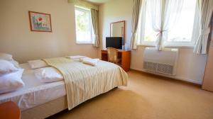 Postel nebo postele na pokoji v ubytování Bernadett Villa Apartman 2