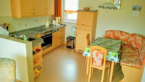 a kitchen with a small table and a kitchen with a toy kitchen at Ferienhaus Riedl in Klingenthal +11 photos