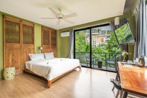 a bedroom with a bed and a large window at See Sea Villa Phuket SHA in Patong Beach