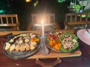 a table with two plates of food and a candle at Minas Em Marambaia in Rio de Janeiro