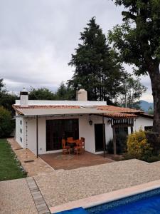 バジェ・デ・ブラボにあるcasa campiranaのパティオとスイミングプール付きのホワイトハウスです。