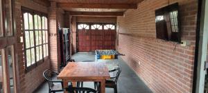 a room with a table and chairs and a brick wall at Casa quinta vacacional in Mar del Tuyú +12 photos
