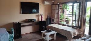 a living room with a bed and a tv at Casa quinta vacacional in Mar del Tuyú