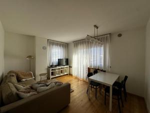 a living room with a couch and a table at Appartamento vista Dolomiti in Pieve di Cadore