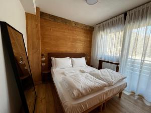 a bedroom with a bed with a wooden wall at Appartamento vista Dolomiti in Pieve di Cadore