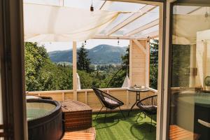 a screened in porch with a hot tub and a table and chairs at Ringat-Lak Panoramic hideout just for 2 in Nagymaros