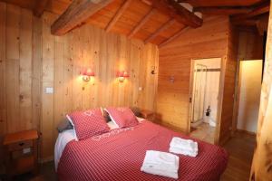 a bedroom with a bed in a wooden cabin at Chalet cosy pour 13 sauna in Saint-Martin-de-Belleville