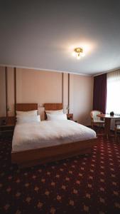 a hotel room with a large bed and a table at Hotel Resi Beverungen in Beverungen