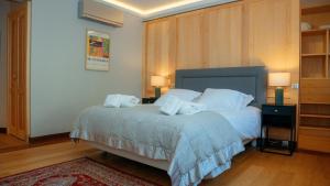 a bedroom with a bed with white sheets and pillows at Superbe appartement traversant 132m2, classé 5 étoiles, Sarlat centre in Sarlat-la-Canéda