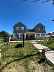 ein Haus mit einem Baum davor in der Unterkunft Alta Montaña Apart in El Chalten