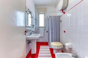 a white bathroom with a toilet and a sink at Le Carrube Vista Mare in Andrano +13 photos