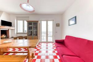 a living room with a red couch and a table at Le Carrube Vista Mare in Andrano