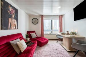 uma sala de estar com um sofá vermelho e uma mesa em Apartment Kandahar 42 em Crans-Montana