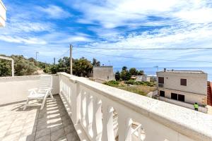 a white chair sitting on the balcony of a building at Le Carrube Vista Mare in Andrano